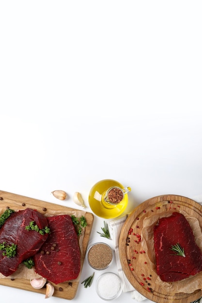 Concepto de cocinar con filetes de carne cruda sobre fondo blanco.