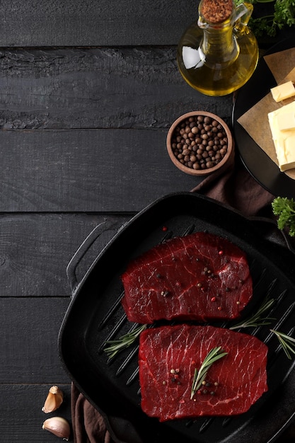 Concepto de cocinar con filetes de ternera crudos en una mesa de madera oscura