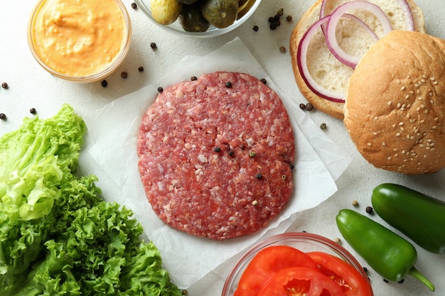 Concepto de cocinar hamburguesa sobre fondo blanco con textura