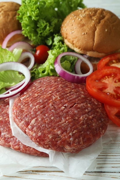 Concepto de cocinar hamburguesas en la mesa de madera blanca