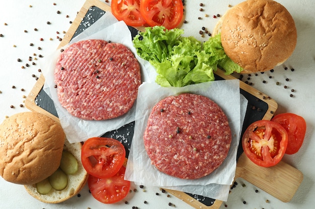 Concepto de cocinar hamburguesas en la mesa con textura blanca