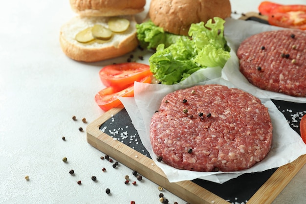 Foto concepto de cocinar hamburguesas en la mesa con textura blanca