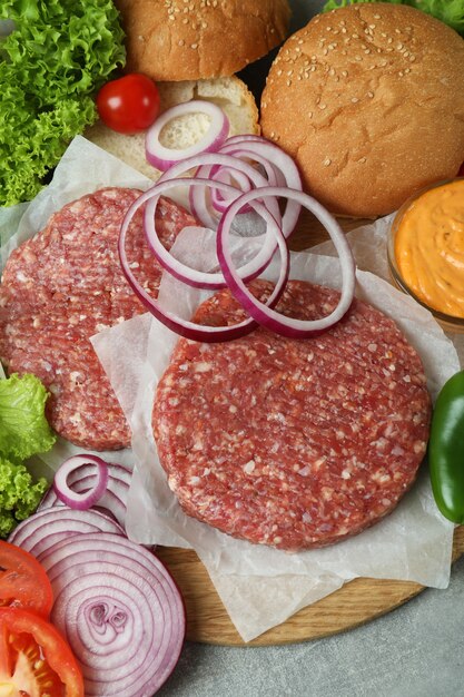 Foto concepto de cocinar hamburguesas en mesa con textura gris