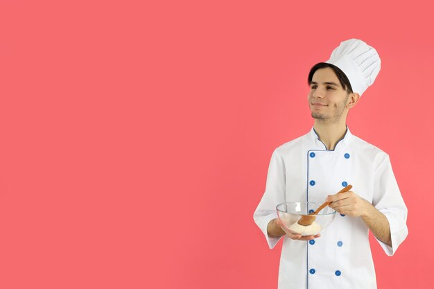 Concepto de cocinar joven chef masculino sobre fondo rosa