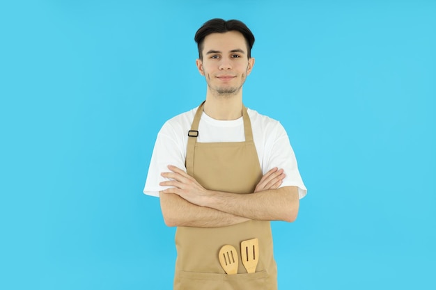 Concepto de cocinar joven chef sobre fondo azul.