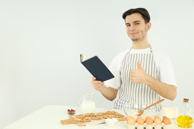 Concepto de cocinar joven en delantal sobre fondo claro