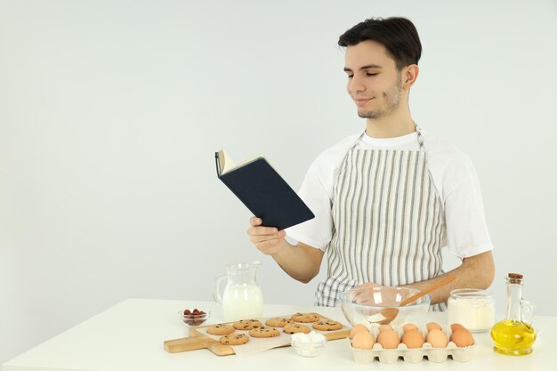 Concepto de cocinar joven en delantal sobre fondo claro