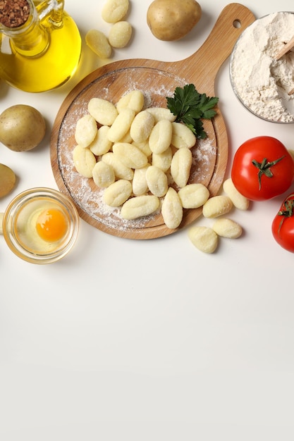 Concepto de cocinar con ñoquis de patata sobre fondo blanco.