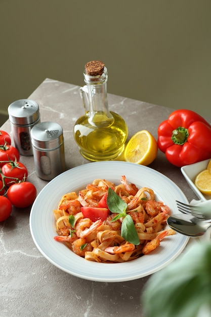 Concepto de cocinar pasta de camarones en mesa con textura gris