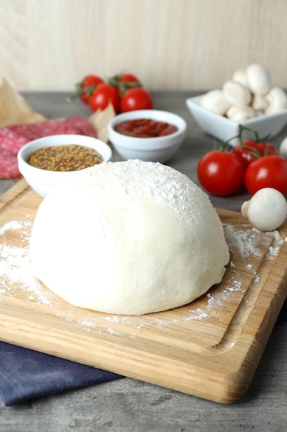 Concepto de cocinar pizza en mesa de madera gris