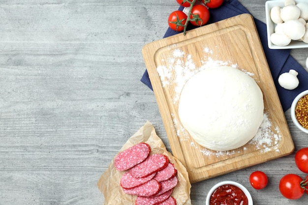 Concepto de cocinar pizza sobre fondo de madera gris