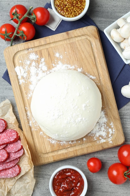 Concepto de cocinar pizza sobre fondo de madera gris