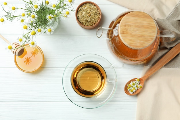 Concepto de cocinar té de manzanilla en la mesa de madera blanca