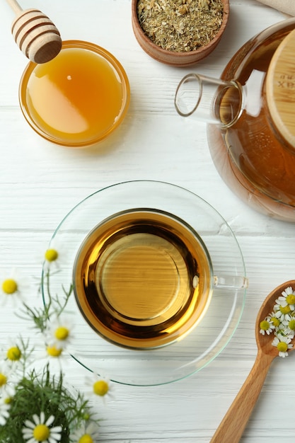 Concepto de cocinar té de manzanilla en la mesa de madera blanca