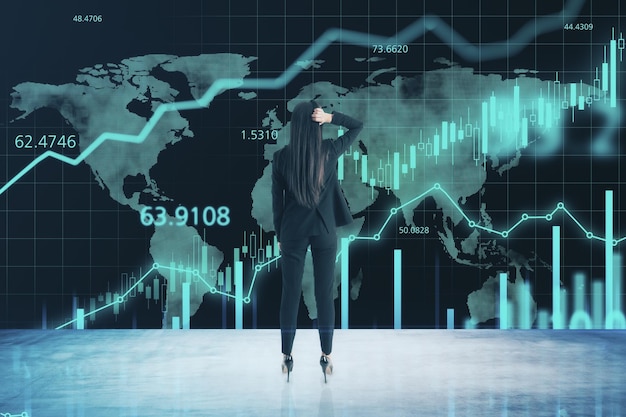 Concepto de comercio en línea en todo el mundo con una mujer comerciante mirando una pantalla grande con gráficos de gráficos financieros digitales y candelabros en crecimiento