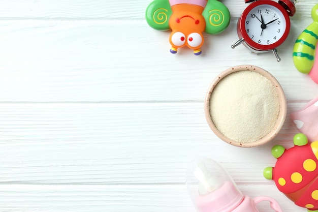 Concepto de comida para bebés con Ñ € owdered leche sobre fondo blanco de madera