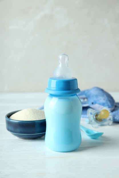 Concepto de comida para bebés con Ã'Â € owdered milk sobre mesa de madera blanca