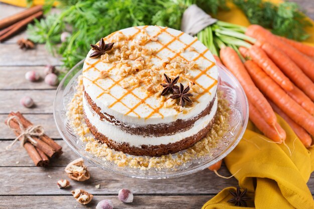 Concepto de comida y bebida. Pastel de zanahoria casero saludable con nueces, nueces y especias en una mesa de cocina rústica. Postre de pascua