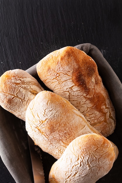 Concepto de comida casera artesanal clásica masa de levadura de estilo italiano Pan de chapata en pizarra negra con espacio de copia