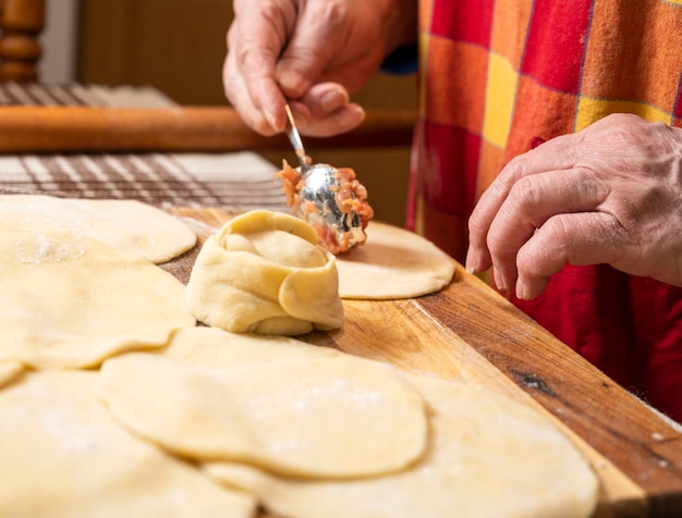 Concepto de comida casera. Mujer haciendo manti con carne picada