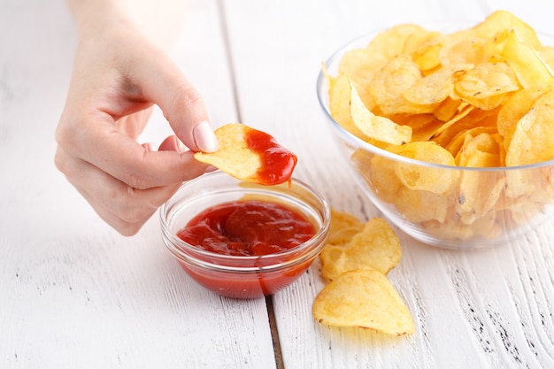 Concepto de comida chatarra grasa, mujer mantenga papas fritas con salsa de tomate