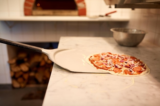concepto de comida, cocina italiana, culinaria, horneado y cocina: pelar la pizza de la mesa en la pizzería