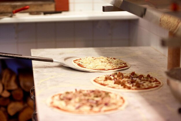 Foto concepto de comida, cocina italiana, culinaria, horneado y cocina: pelar la pizza de la mesa en la pizzería