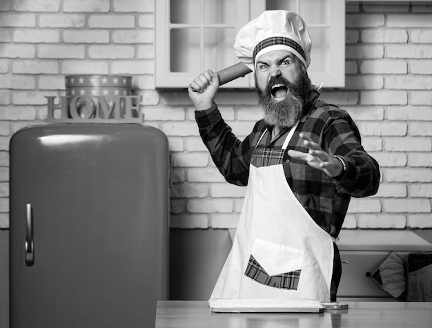 Concepto de comida de cocina Sosteniendo un rodillo apretando el puño gritando