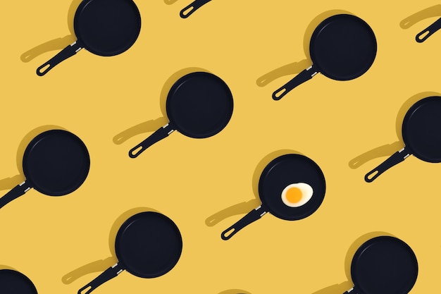 Concepto de comida creativa con caramelos gomosos en forma de huevo frito en una sartén negra sobre fondo amarillo Vista superior del desayuno de la mañana Patrón sin costuras Estilo minimalista Lay plano Espacio de copia