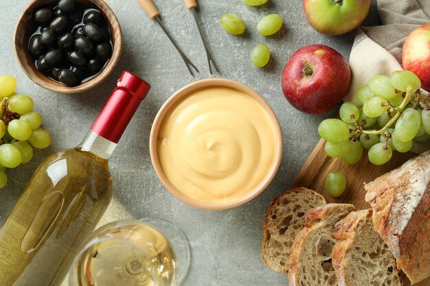 Concepto de comida deliciosa con fondue en mesa con textura gris