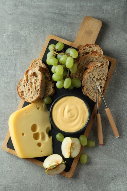 Concepto de comida deliciosa con fondue en mesa con textura gris