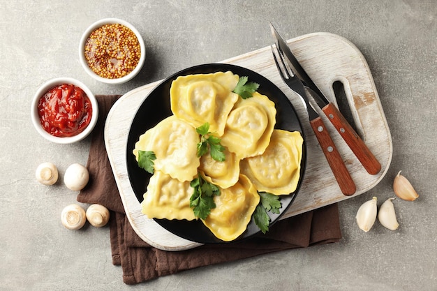 Concepto de comida deliciosa con ravioles sobre fondo gris