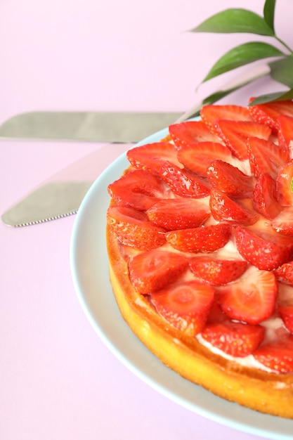 Concepto de comida deliciosa con tarta de fresa sobre fondo violeta.