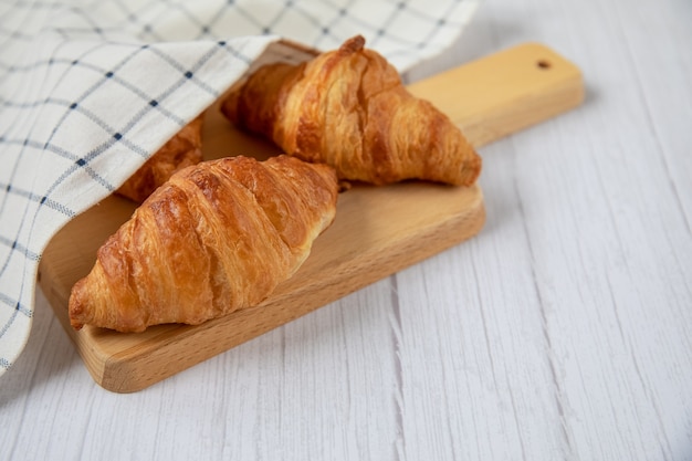 Concepto de comida deliciosos croissants frescos en una tabla de madera