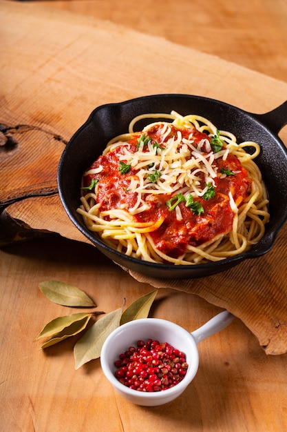 Concepto de comida Espaguetis caseros boloñesa en hierro fundido.