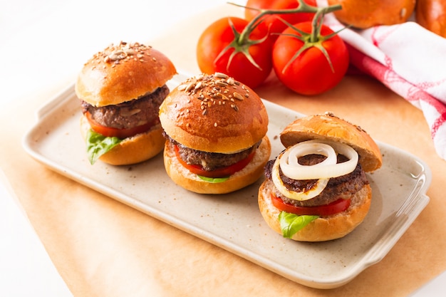 Concepto de comida Las hamburguesas caseras de carne sirven en un plato cuadrado en blanco con espacio de copia