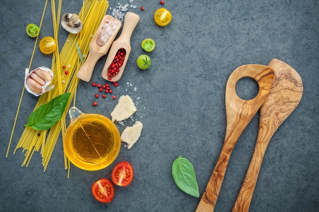 Concepto de comida italiana y diseño de menú. Pasta con ingredientes en el fondo de piedra.