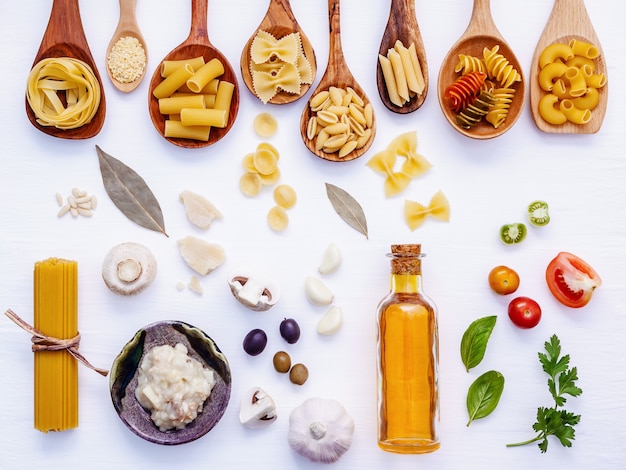 Concepto de comida italiana y diseño de menú. Pasta con ingredientes sobre fondo blanco.