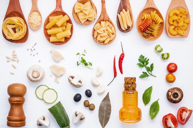 Concepto de comida italiana y diseño de menú. Pasta con ingredientes sobre fondo blanco.