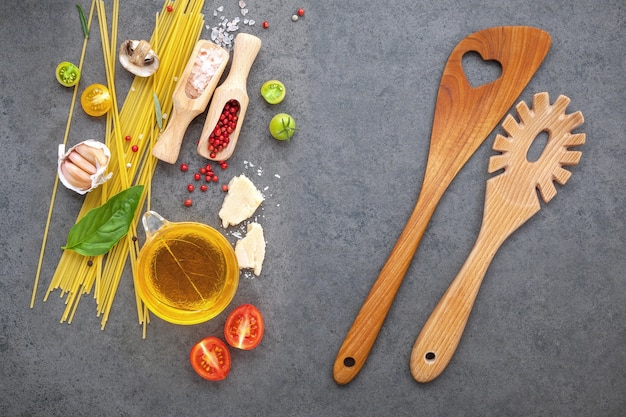 Concepto de comida italiana. Los espaguetis con los ingredientes en el plano oscuro del fondo ponen y copian el espacio.