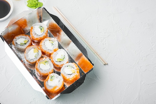 Concepto de comida japonesa. Catering, diversos tipos de sushi philadelphia rolls y rollitos de gambas al horno, en piedra blanca