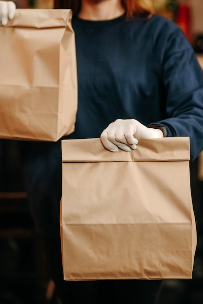 Foto concepto de comida para llevar. chica en guantes blancos tiene comida para llevar envasada