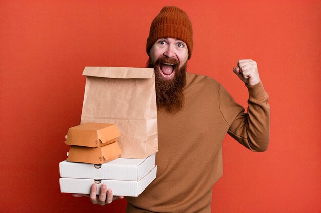 Concepto de comida para llevar y entrega de hombre fresco de barba larga y cabello rojo