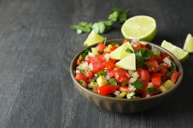 Concepto de comida mexicana con Pico de Gallo en mesa de madera oscura.
