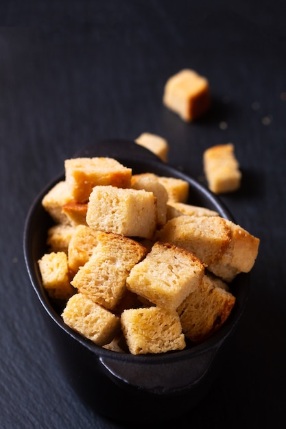 Concepto de comida pan de crutones orgánicos caseros sobre fondo negro con espacio de copia