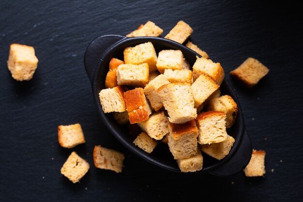 Concepto de comida pan de crutones orgánicos caseros sobre fondo negro con espacio de copia