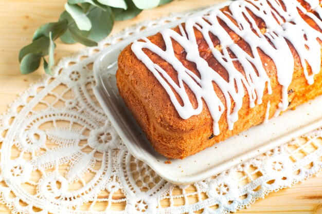 Concepto de comida Pan hecho en casa de ron de vainilla, pasas de mantequilla, cobertura de pasteles por glaseado real