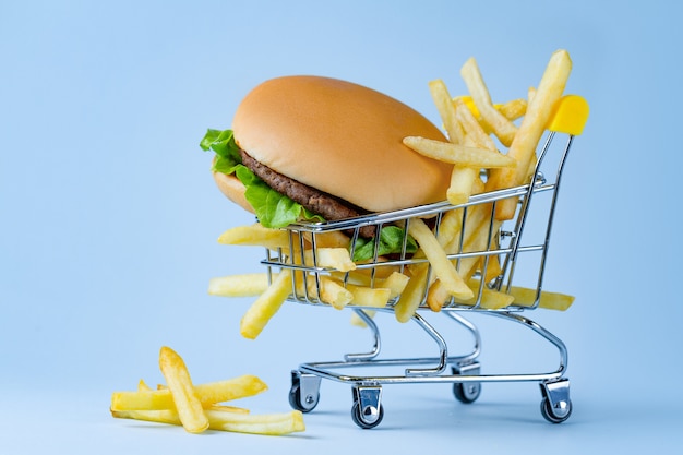 Concepto de comida. Papas fritas y hamburguesas para la merienda. Basura, carbohidratos y alimentos poco saludables.