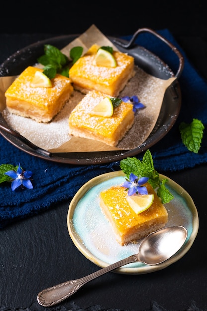 Concepto de comida pastel de barra de limón rústico casero sobre fondo negro con espacio de copia