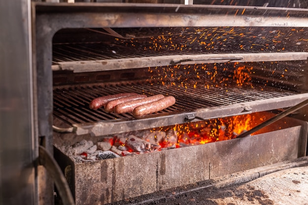 Concepto de comida, platos deliciosos y de carne: salchichas de caballo preparadas en barbacoa.